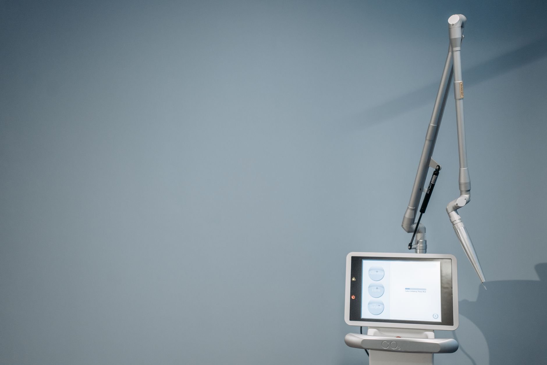 A high-tech medical device with a tablet screen in a clinical environment.